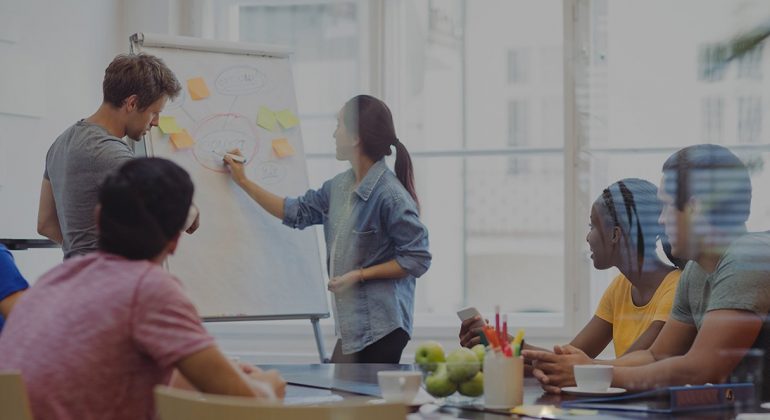 Business executives discussing with their colleagues on whiteboard